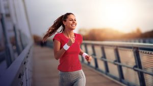 Smiling woman running on a bridge